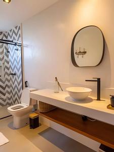 a bathroom with a sink and a toilet and a mirror at Casa Kai - Costa Dourada in Onça