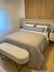 ein Schlafzimmer mit einem Bett und einer Bank daneben in der Unterkunft Suite no centro de Doutor Pedrinho in Rio Forcação