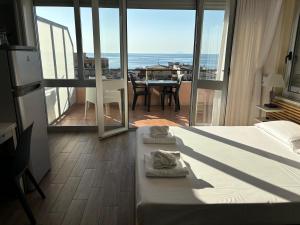 a bedroom with a bed and a view of a balcony at Blue Sky Apartments in Capo dʼOrlando