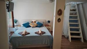 a bedroom with a bed with blue pillows and a ladder at Tisno Stone House on the Cove in Tisno