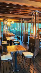a restaurant with wooden tables and chairs and windows at Sonidos Del Bosque in Mar de las Pampas