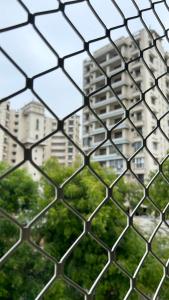 a view through a chain link fence of a building at Himaksh Homestay in Varanasi