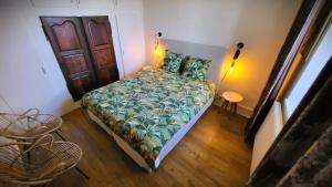 a bedroom with a bed with a green comforter at Appartement du Fort Griffon in Besançon