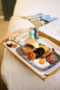 a tray of breakfast foods on a bed at Milford Hall Salisbury in Salisbury