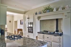 a kitchen with white cabinets and a counter top at Alward House by Group Retreats in Salisbury