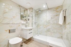 a white bathroom with a tub and a toilet and a sink at Milford Hall Salisbury in Salisbury