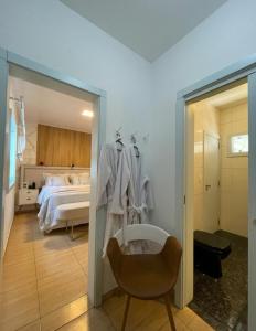 ein Schlafzimmer mit einem Bett, einer Badewanne und einem Stuhl in der Unterkunft Suite no centro de Doutor Pedrinho in Rio Forcação