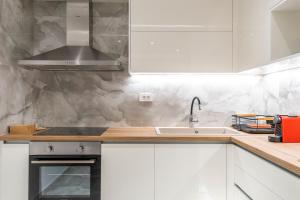 a kitchen with white cabinets and a sink at Orion Luxury Apartments in Nafplio