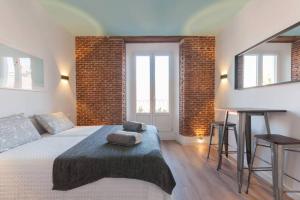 a bedroom with a bed and a brick wall at ºººººPS New Atocha City Centre WiFi AC SmartTVººººº in Madrid