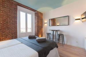 a bedroom with a bed and a brick wall at ºººººPS New Atocha City Centre WiFi AC SmartTVººººº in Madrid