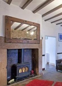 a fireplace in a living room with a stove at Commerce Cottage Rooms in Ripley