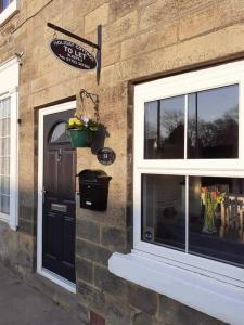 a brick building with a door and a window at Commerce Cottage Rooms in Ripley