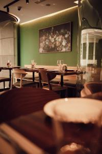 a row of tables in a restaurant with green walls at Hotel Indigo Madrid - Gran Vía by IHG in Madrid