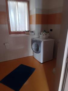 niewielka łazienka z pralką i oknem w obiekcie la farfalla di Susà w mieście Pergine Valsugana