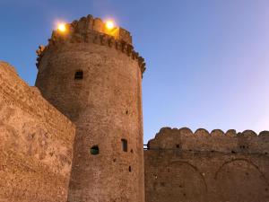 a castle with two lights on top of it at Papavero Giallo B&B in Le Castella