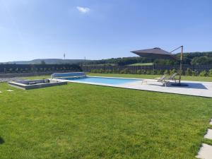 a swimming pool in a yard with green grass at Echappée des Hirondelles in Richemont
