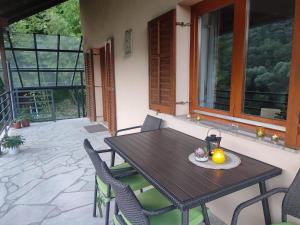a wooden table and chairs on a patio at Villa Beata Apartment 1 upper floor in Kulen Vakuf