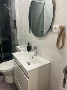 a bathroom with a sink and a mirror and a toilet at Friend's House in Maia