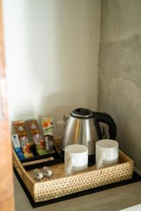 a tray with a tea kettle and cups on a counter at Zen Villa in Ahangama