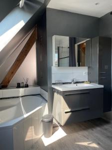 a bathroom with a sink and a mirror at Chez L en Alsace - Maison avec jardin et piscine spa proche d'Obernai in Griesheim-près-Molsheim +37 photos