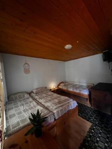 2 bedden in een kamer met houten plafonds bij Вила Еделвайс in Dobrinishte +14 foto's
