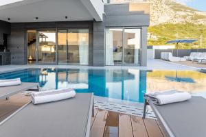 a house with a swimming pool with two chairs at Villa Magnus in Makarska