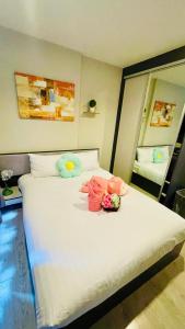 a bedroom with a large white bed with flowers on it at The base Central Pattaya 338 by Numam in Pattaya +48 photos