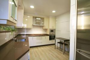 a kitchen with white cabinets and a black table at Casa en Fontecova in Cuntis
