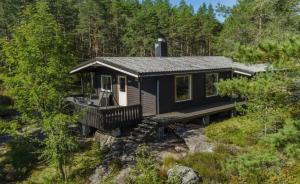 a blue house with a deck in the woods at Tonstad hytta in Tonstad