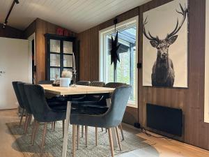 a dining room with a table and a deer picture on the wall at Tonstad hytta in Tonstad