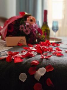 a table with red rose petals and a bottle of wine at Villa Maskali in Cuxac-dʼAude +34 photos