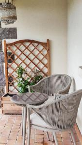 un patio con mesa, 2 sillas y una mesa en Studio neuf dans maison avec piscine partagée, en Riom 1 foto más
