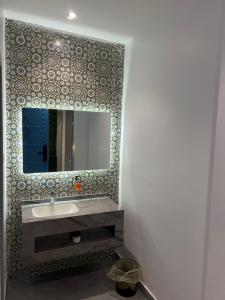 un bagno con lavandino e specchio di نزل بيبا a Riyad