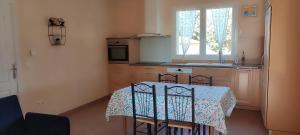 a kitchen with a table and chairs and a window at Les hirondelles de L'Embisque in Bollène