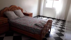 a bedroom with a bed and a checkered floor at Appartement de vacances 2 chambres à Saidia 2 min de la plage à pied in Saidia 