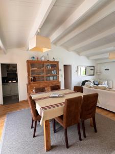 a dining room with a table and chairs and a bedroom at Maison de Vacances des Centaurées in La Guérinière