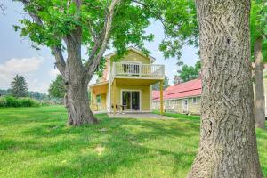 a yellow house with a porch and two trees at Adirondacks Cottage with Countryside Views! in Moriah