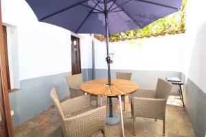 a table and chairs with a purple umbrella at El Pintaillo by SIERRA VIVA in Cortelazor