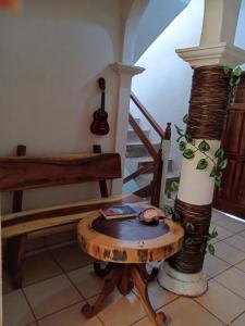 a room with a table and a bench and a guitar at ESPERANZA Casa de Huéspedes in Puerto Escondido