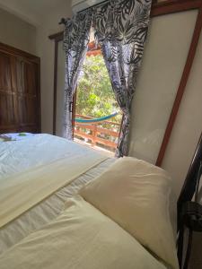 a bedroom with a bed and a window at ESPERANZA Casa de Huéspedes in Puerto Escondido
