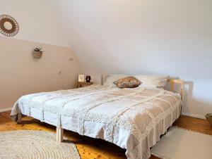 a bedroom with a bed with a white comforter at Boho room in Coburg