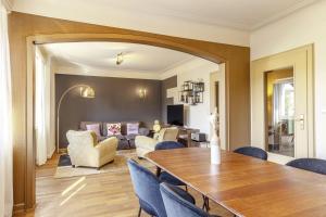 a dining room with a table and chairs and a living room at Stylish 2BR Apt with Balcony & Views near Center in Luxembourg