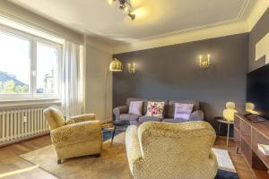 a living room with two chairs and a couch at Stylish 2BR Apt with Balcony & Views near Center in Luxembourg