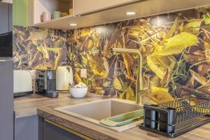 a kitchen with a leafy wallpaper on the wall at Stylish 2BR Apt with Balcony & Views near Center in Luxembourg +10 photos