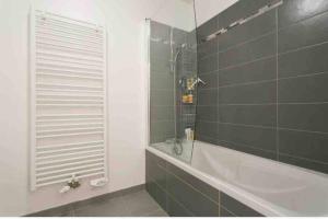 a bathroom with a shower and a bath tub at Cozy & Quiet Getaway Just 300m from Paris with Free Private Parking in Gentilly