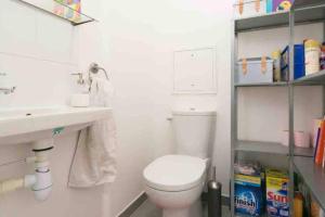 a white bathroom with a toilet and a sink at Cozy & Quiet Getaway Just 300m from Paris with Free Private Parking in Gentilly +5 photos