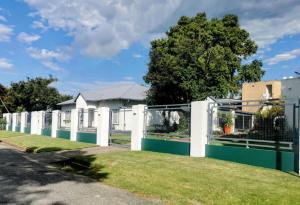 a white and green fence in front of a house at Eljé's Cottage in Parys