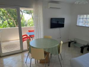 a living room with a table and chairs and a television at Apartments MiaMaja in Novalja