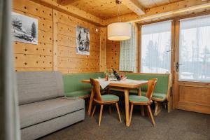 a dining room with a table and chairs and a couch at Thurntaler Rast in Außervillgraten +45 photos