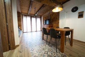 Un comedor con mesa y sillas de madera. en Casa Vacanza Vecchia Mura, en Mura